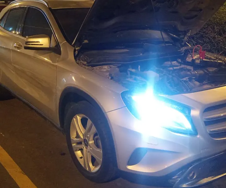 Camioneta con el capó abierto y luces encendidas durante una asistencia nocturna
