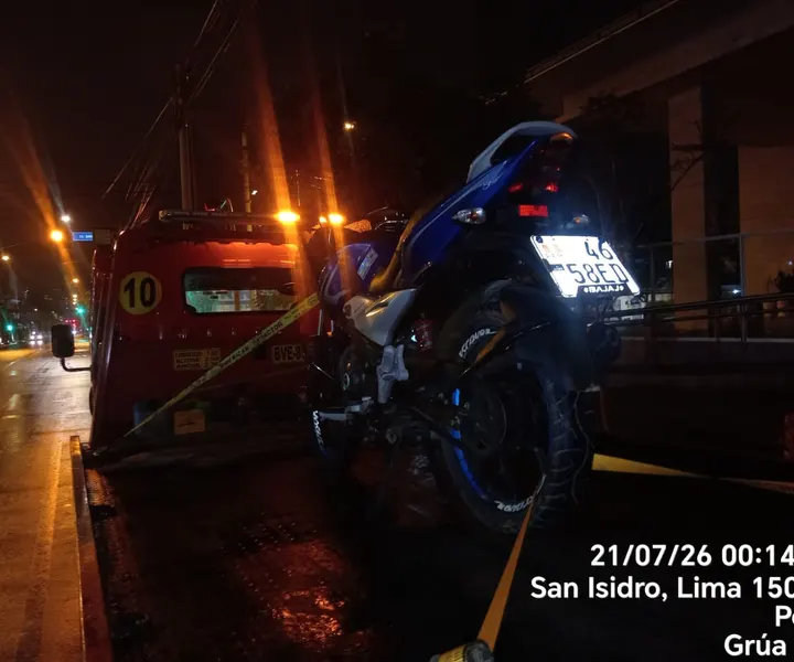 Motocicleta asegurada sobre una plataforma de grúa durante un traslado nocturno.